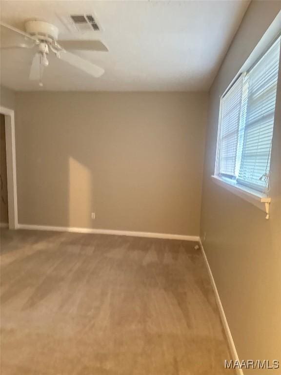 carpeted spare room with ceiling fan