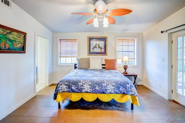 tiled bedroom with multiple windows and ceiling fan