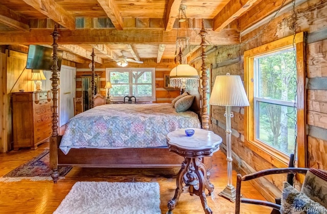 bedroom featuring hardwood / wood-style floors, wooden ceiling, beamed ceiling, and multiple windows