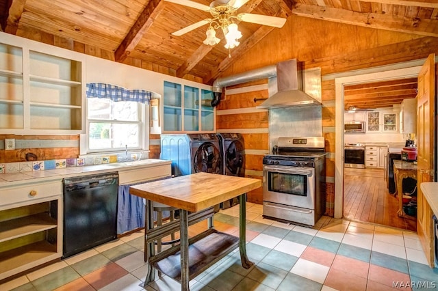 kitchen with stainless steel appliances, wall chimney range hood, lofted ceiling with beams, wooden ceiling, and washing machine and clothes dryer