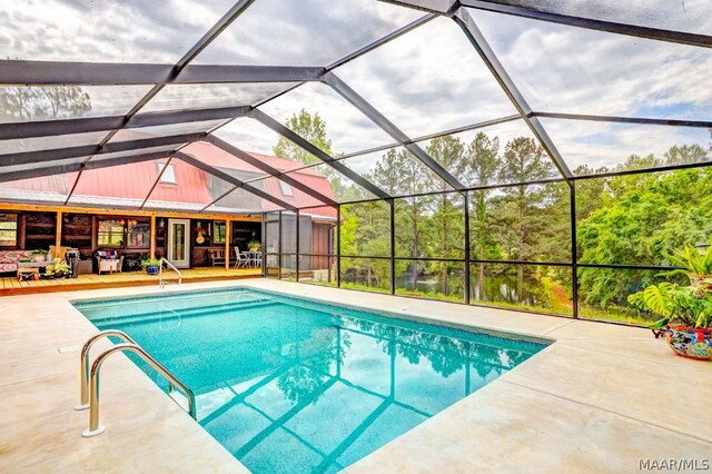 view of swimming pool featuring glass enclosure and a patio area