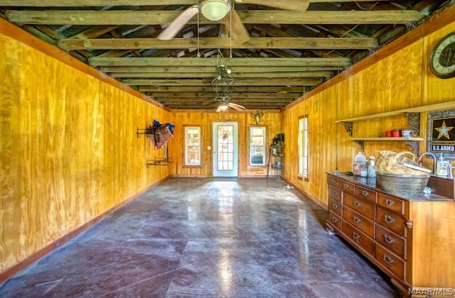 misc room with beamed ceiling, ceiling fan, and wooden walls