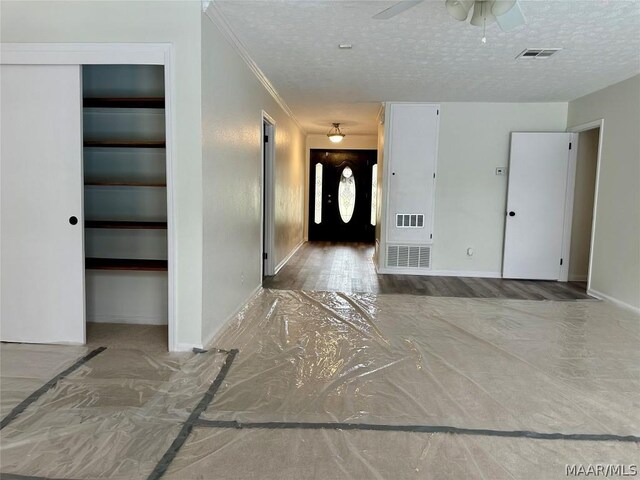 foyer with hardwood / wood-style floors, ceiling fan, crown molding, and a textured ceiling