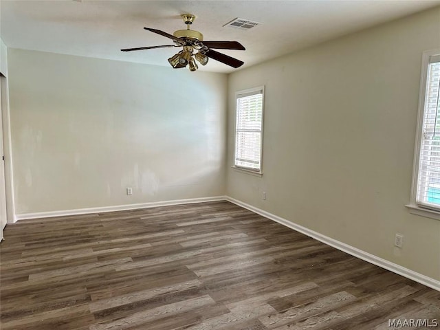 unfurnished room with a wealth of natural light, dark hardwood / wood-style flooring, and ceiling fan