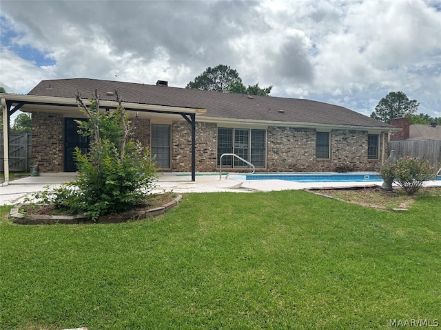 rear view of property featuring a yard and a patio