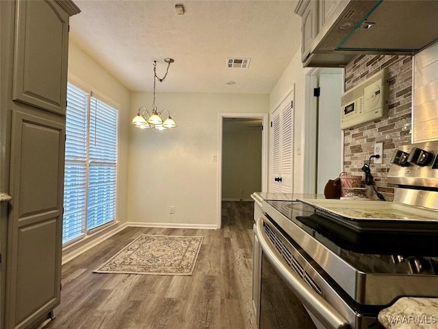 kitchen with gray cabinetry, stainless steel electric range oven, an inviting chandelier, dark hardwood / wood-style floors, and decorative light fixtures