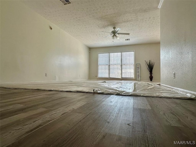 empty room featuring hardwood / wood-style flooring, ceiling fan, and a textured ceiling