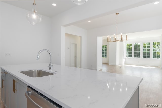 kitchen featuring a kitchen island with sink, light hardwood / wood-style floors, dishwasher, and sink