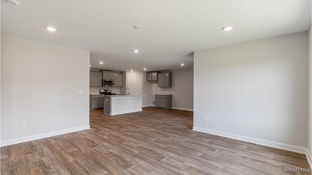 unfurnished living room featuring sink and light wood-type flooring