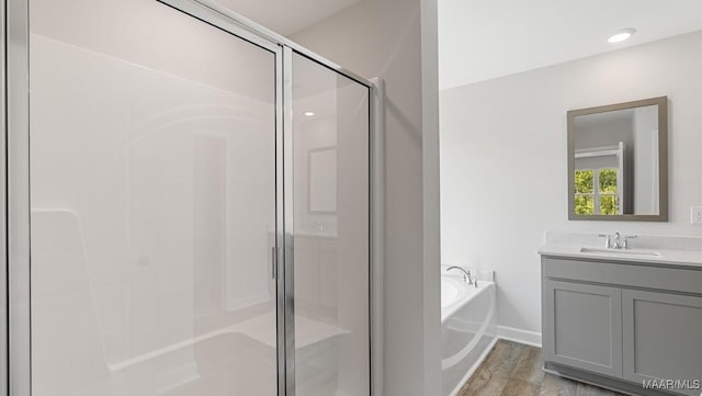 bathroom with vanity, plus walk in shower, and hardwood / wood-style floors