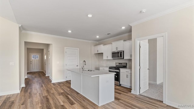 6601 Firefly Ln, Montgomery, AL 36116 - kitchen featuring stainless steel appliances, a sink, wood finished floors, white cabinetry, and crown molding