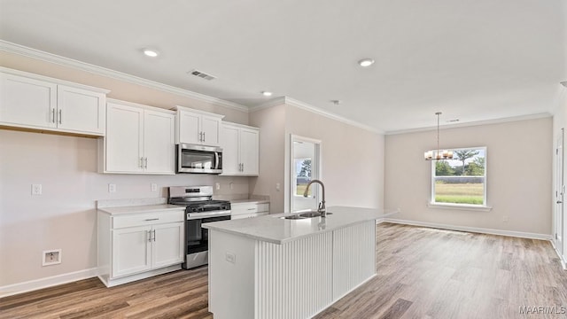 6601 Firefly Ln, Montgomery, AL 36116 - kitchen featuring appliances with stainless steel finishes, a sink, white cabinets, light wood-style flooring, and light countertops