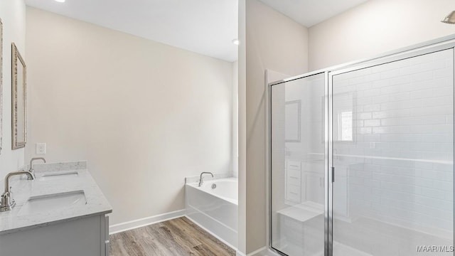 6601 Firefly Ln, Montgomery, AL 36116 - bathroom with wood finished floors, a shower stall, a bath, double vanity, and baseboards