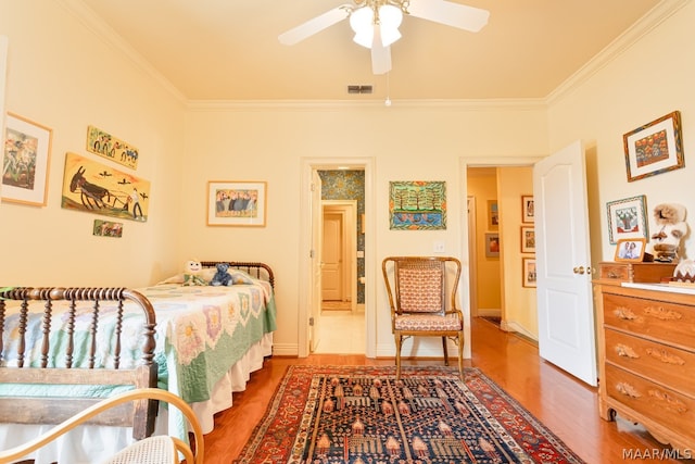 bedroom featuring wood-type flooring, ceiling fan, and crown molding