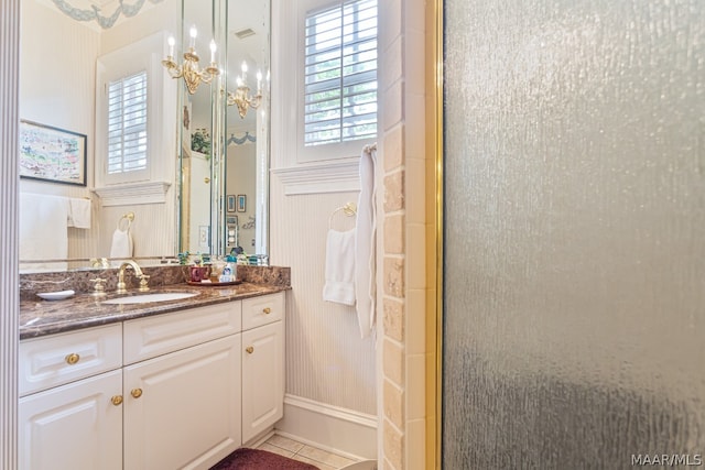 bathroom featuring a shower with shower door, vanity with extensive cabinet space, and tile flooring