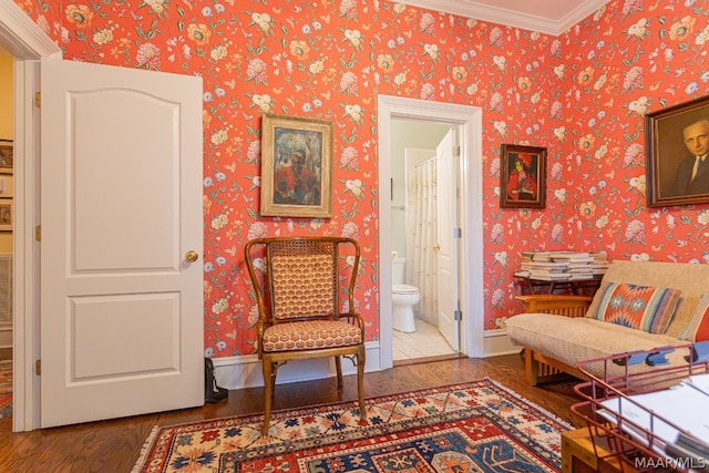 sitting room with ornamental molding and wood-type flooring