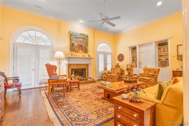 living room featuring hardwood / wood-style floors, ceiling fan, and ornamental molding