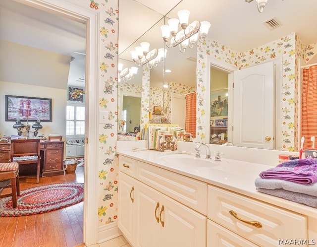 bathroom featuring vanity, hardwood / wood-style flooring, and an inviting chandelier