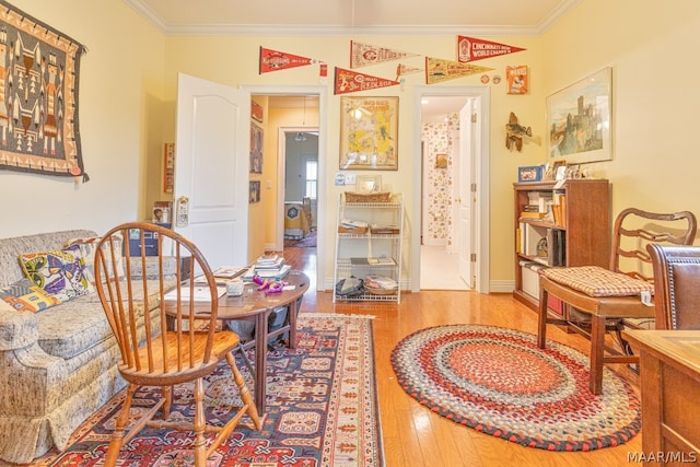 sitting room featuring ornamental molding and hardwood / wood-style flooring