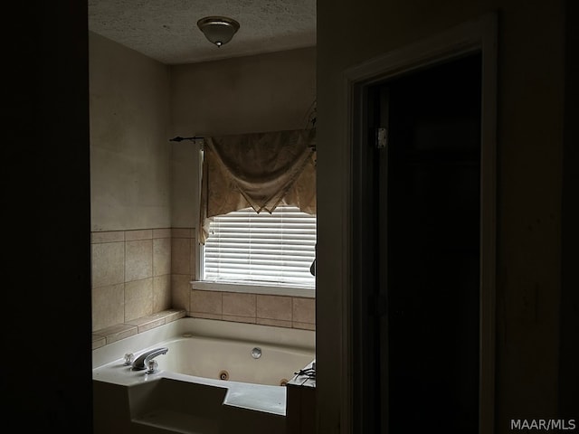 bathroom with a bath to relax in and a textured ceiling