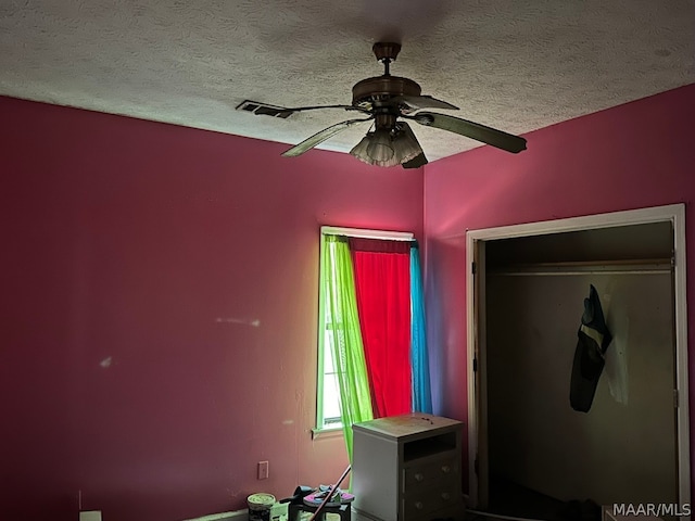 interior space featuring a closet, a textured ceiling, and ceiling fan