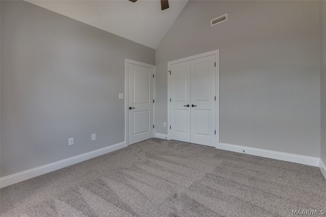 unfurnished bedroom with a closet, high vaulted ceiling, ceiling fan, and carpet flooring