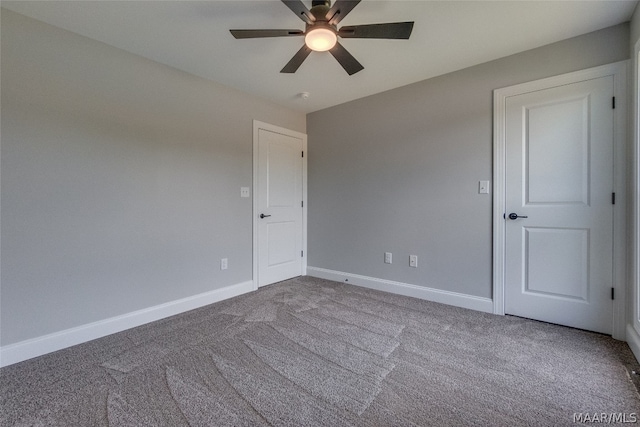 empty room featuring ceiling fan and light colored carpet