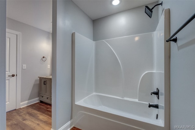 bathroom featuring wood-type flooring, vanity, and  shower combination