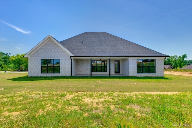 back of property featuring a yard and ceiling fan