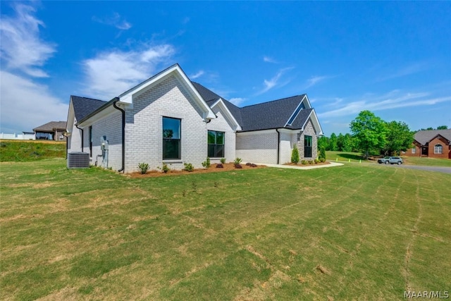 view of front of house with a front yard and central AC