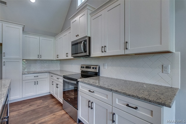 kitchen featuring appliances with stainless steel finishes, white cabinets, lofted ceiling, and light stone countertops