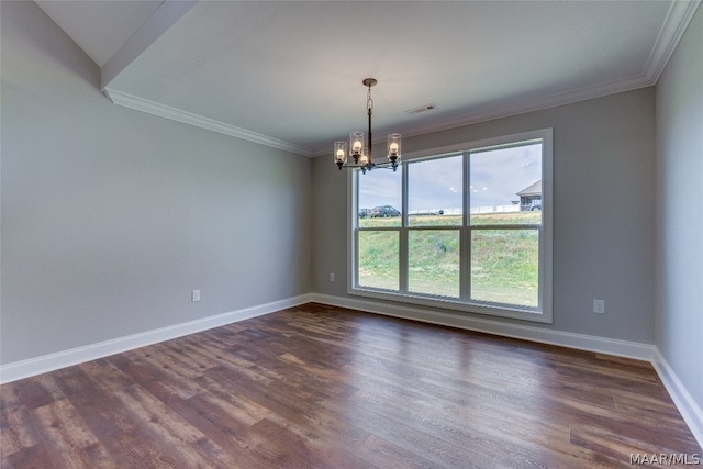 spare room featuring dark hardwood / wood-style flooring, ornamental molding, and a notable chandelier