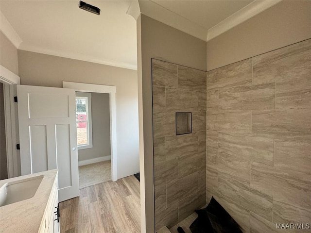 bathroom with hardwood / wood-style flooring, crown molding, and vanity