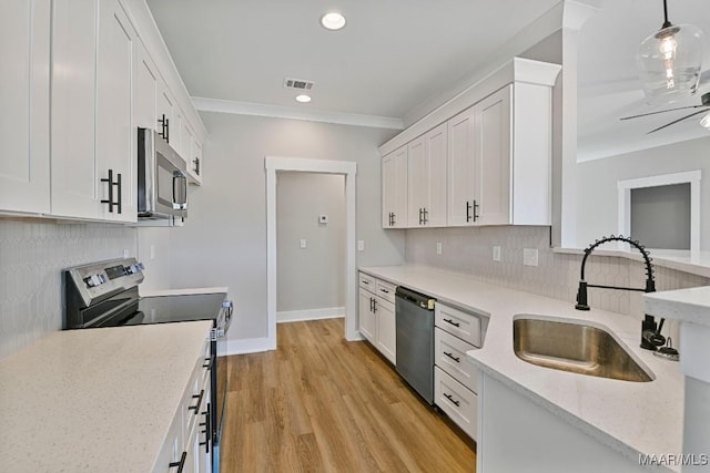 kitchen featuring stainless steel appliances, white cabinetry, sink, and pendant lighting