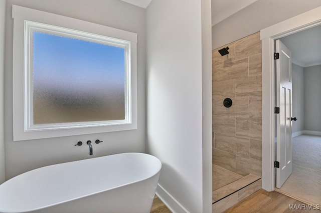 bathroom featuring independent shower and bath and hardwood / wood-style floors