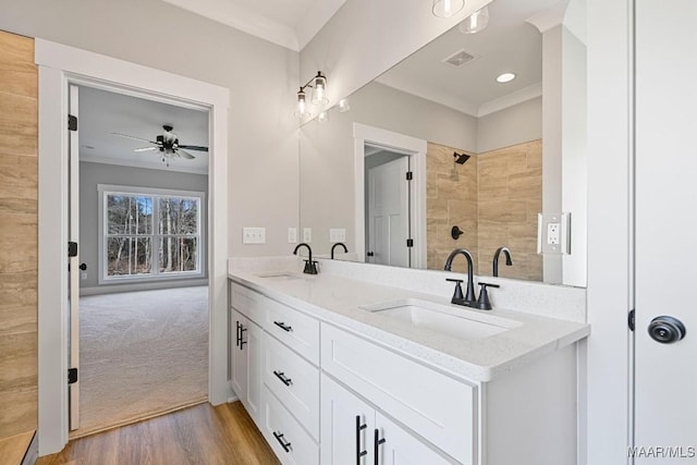 bathroom with crown molding, hardwood / wood-style floors, vanity, and ceiling fan