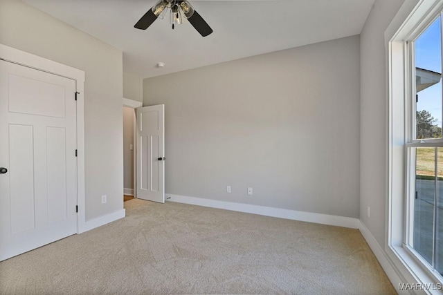 unfurnished bedroom with light colored carpet and ceiling fan