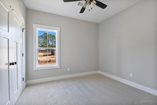 unfurnished room featuring light carpet and ceiling fan