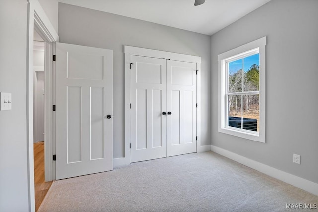 unfurnished bedroom featuring light colored carpet and a closet