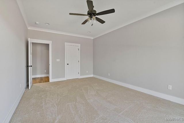 unfurnished bedroom featuring light carpet, crown molding, and ceiling fan