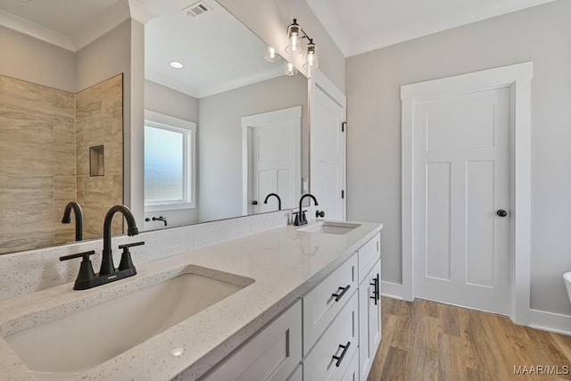 bathroom featuring hardwood / wood-style flooring, vanity, and ornamental molding