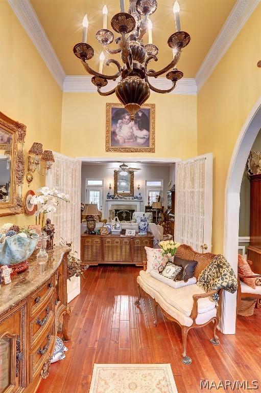 living area with hardwood / wood-style flooring and crown molding