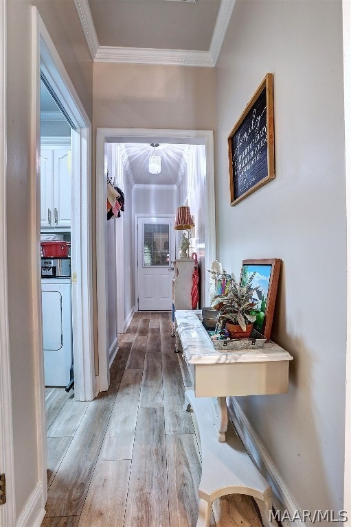 corridor featuring crown molding, washer / clothes dryer, and light hardwood / wood-style flooring