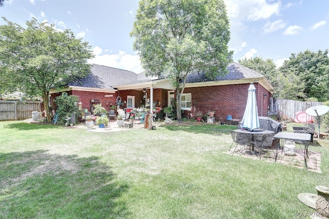 rear view of property featuring a yard and a patio