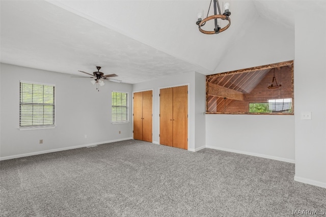 interior space with ceiling fan with notable chandelier and vaulted ceiling