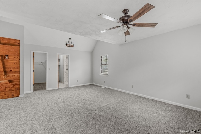 empty room with carpet flooring, vaulted ceiling, and ceiling fan