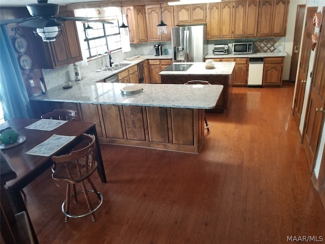 kitchen featuring stainless steel appliances, a breakfast bar, sink, and backsplash