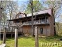 rear view of house with a lawn and a wooden deck