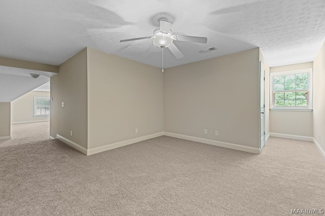 carpeted empty room with ceiling fan and a textured ceiling