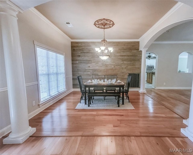 dining space with crown molding, wood-type flooring, and ceiling fan with notable chandelier